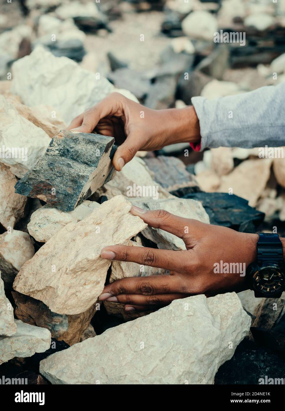 Ein Mann, der Steine stapelt - im Buddhismus wird angenommen, dass das Stapeln der Steine dem Stapler und seiner Familie Glück bringt. Stockfoto