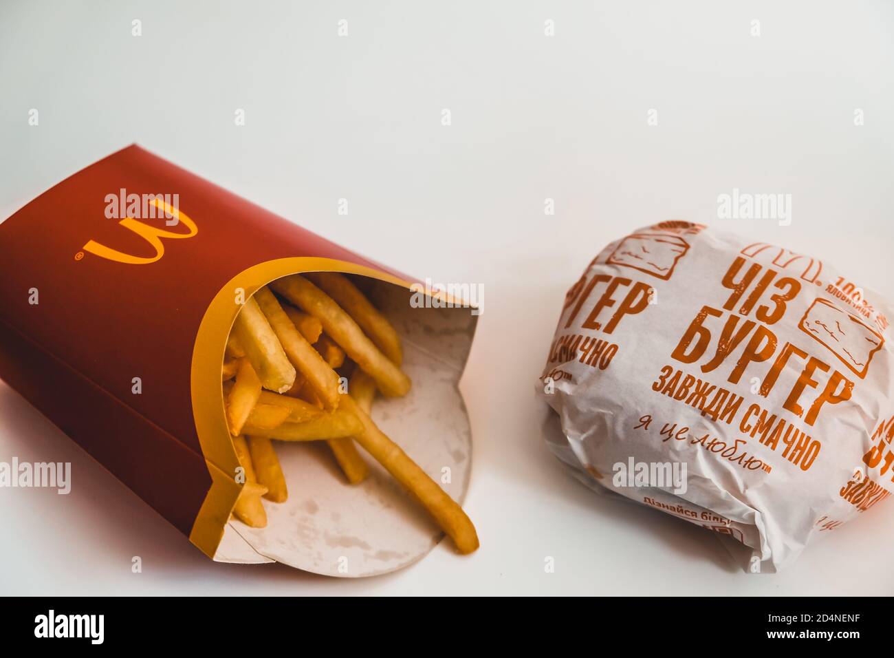Lviv / Ukraine - April 2020: McDonald's pommes Frites und Cheeseburger auf einem weißen Tisch zu Hause. Ungesunde Ernährung während des Coronavirus-Ausbruchs. Bestellung Stockfoto