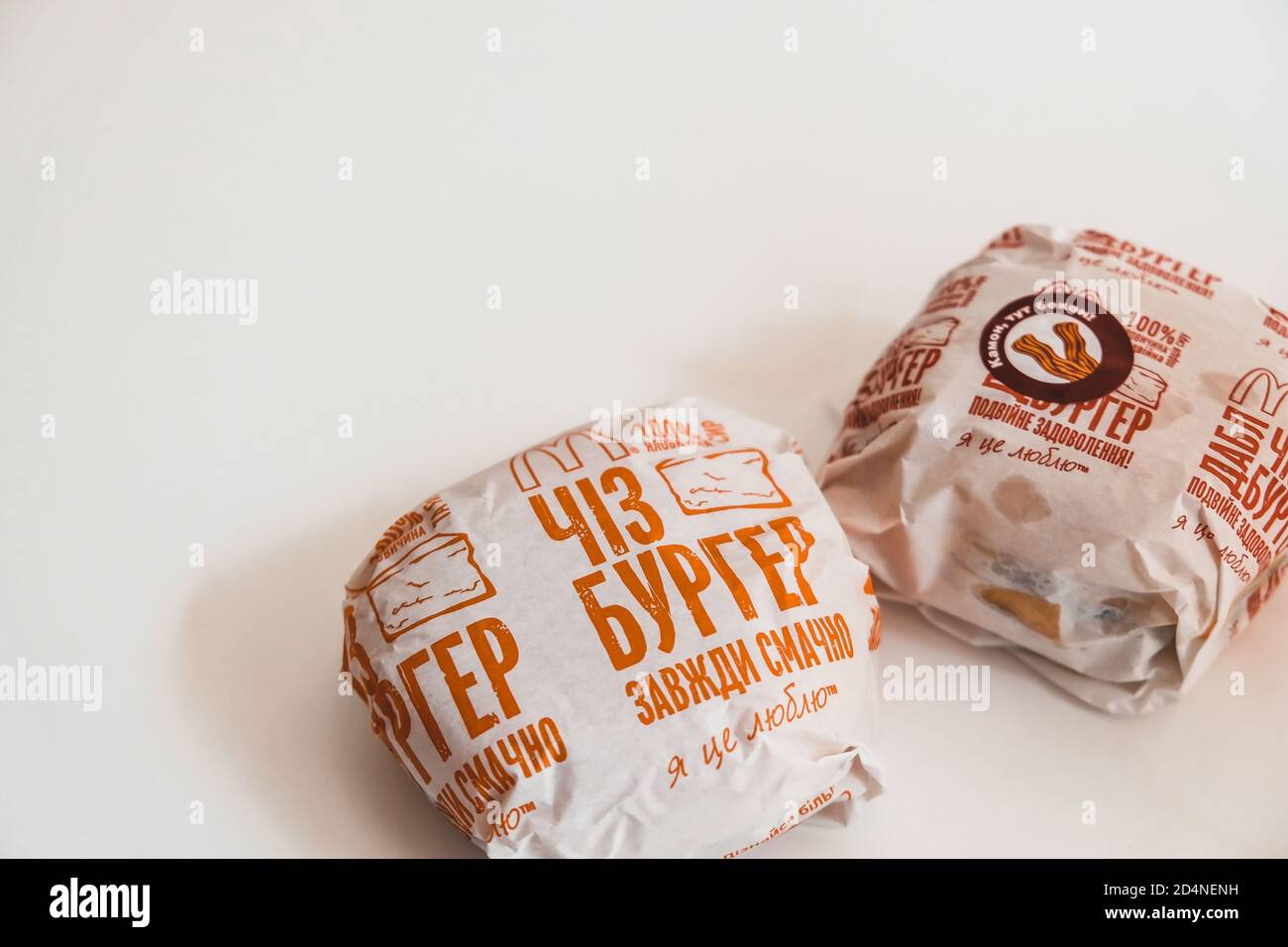 Lviv / Ukraine - April 2020: Zwei Cheeseburger von ukrainischen McDonalds auf einem weißen Tisch zu Hause. Ungesunde Ernährung während des Coronavirus-Ausbruchs. Auftrag Stockfoto