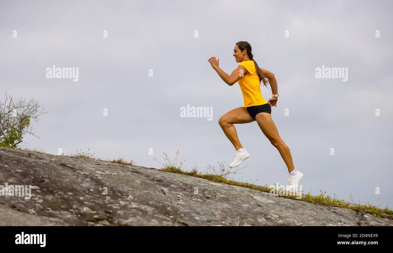 Seitenansicht der Fitness-Frau beim hochintensiven Laufen am Berghang Am Meer Stockfoto