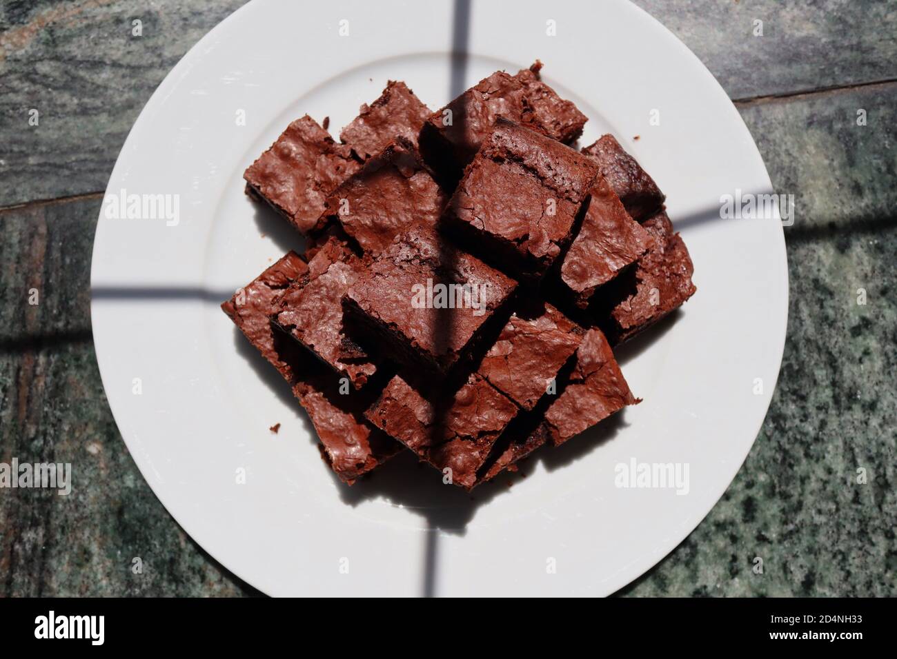 Top-Down Brownies mit Sonnenschein drauf mit ein paar Window Shadows. Blick von oben auf hausgemachten glutenfreien Brownie. Stockfoto