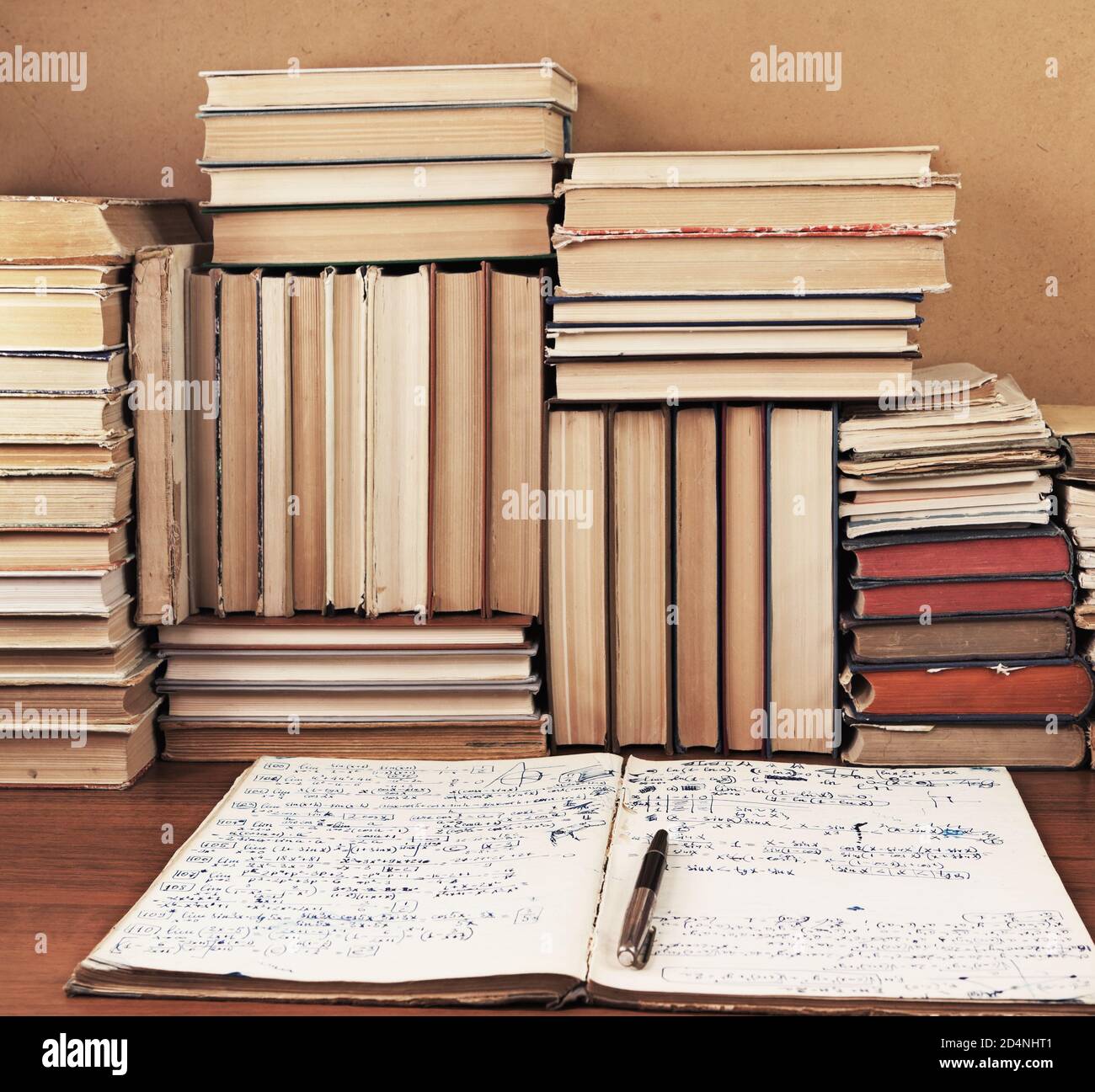 Schreiben-Buch mit mathematischen Vorlesungen vor einem Hintergrund eine Menge Bücher Stockfoto