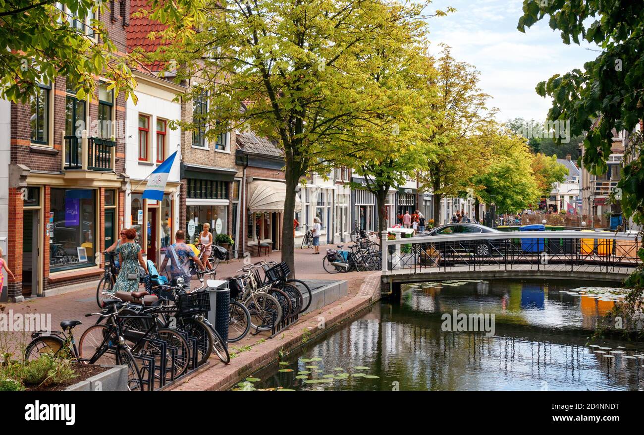 Blick auf die Altstadt von Gouda. Zeugstraat mit Kanal, Brücken und Geschäften an einem sonnigen Nachmittag. Südholland, Niederlande. Stockfoto