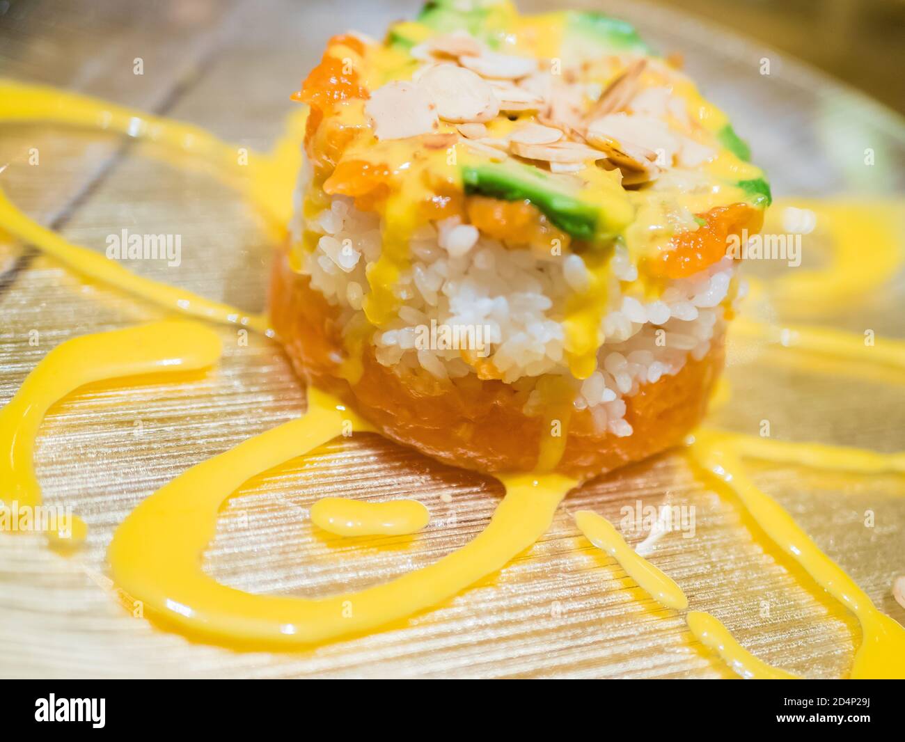 Typisch japanisches Gericht mit Sushi, Reis und Fisch, mit Sauce, Salat, Sushimi und Sesam. Japanischer Burger mit Reis, Lachs, Avocado, Mandeln und d Stockfoto