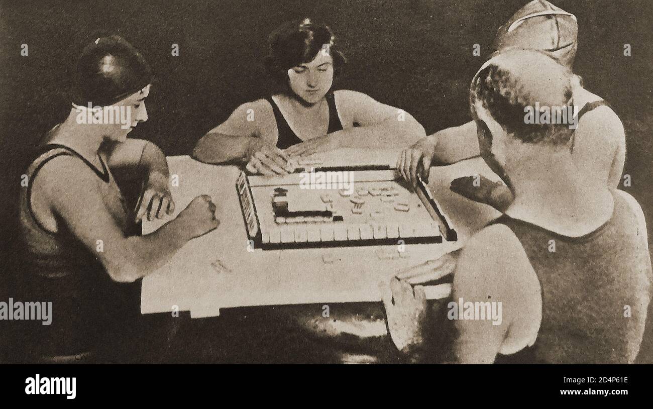 1924 - EINE Familie (seltsam in Schwimmkleidung gekleidet?) Mah Jongg spielen (verschiedene Schreibweisen wie Mah-Jongg, Mahjong, Majong usw.). In diesem Jahr wurde es zum letzten Wahnsten in Großbritannien. Das Spiel wurde während der Qing-Dynastie in China entwickelt und hat sich seitdem in der ganzen Welt seit dem frühen 20. Jahrhundert verbreitet. Stockfoto