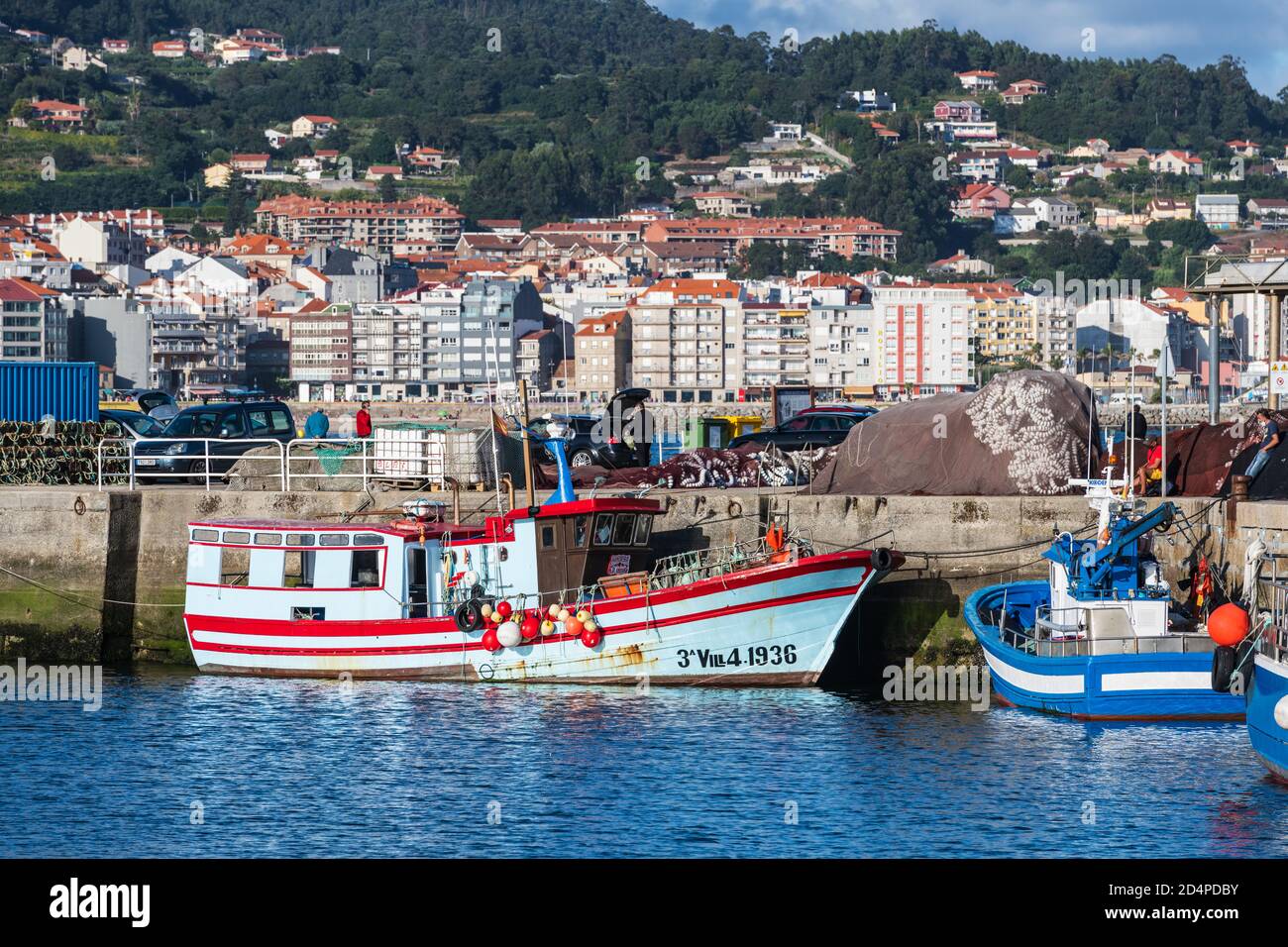 PORTONOVO, SPANIEN - 15. AUGUST 2020: Bunte kleine Fischerboote, die in Portonovo Hafen in der Abenddämmerung, Galizien, Spanien, festgemacht sind. Stockfoto