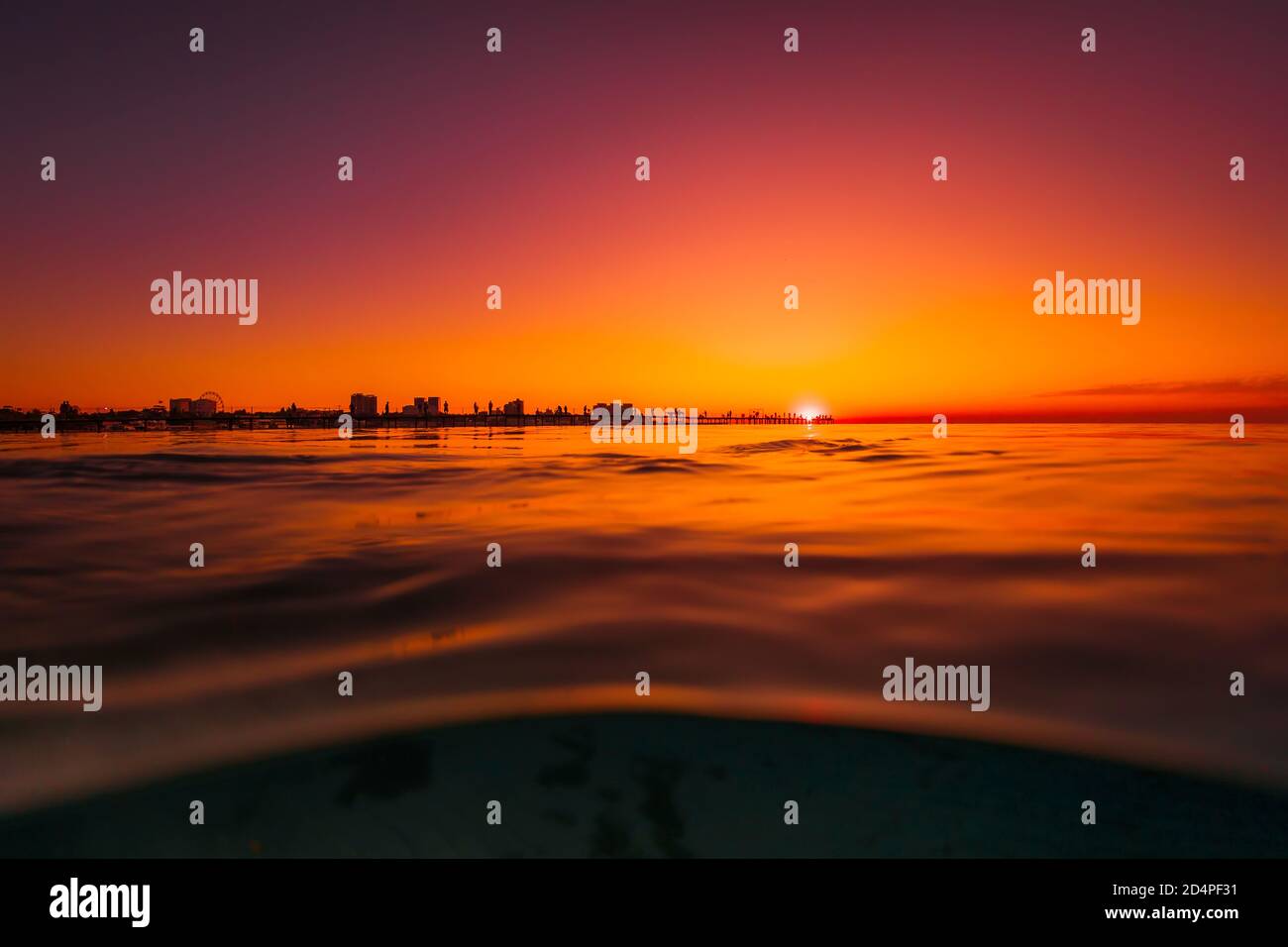 Heller Sonnenuntergang oder Sonnenaufgang am Meer mit Silhouette Stockfoto