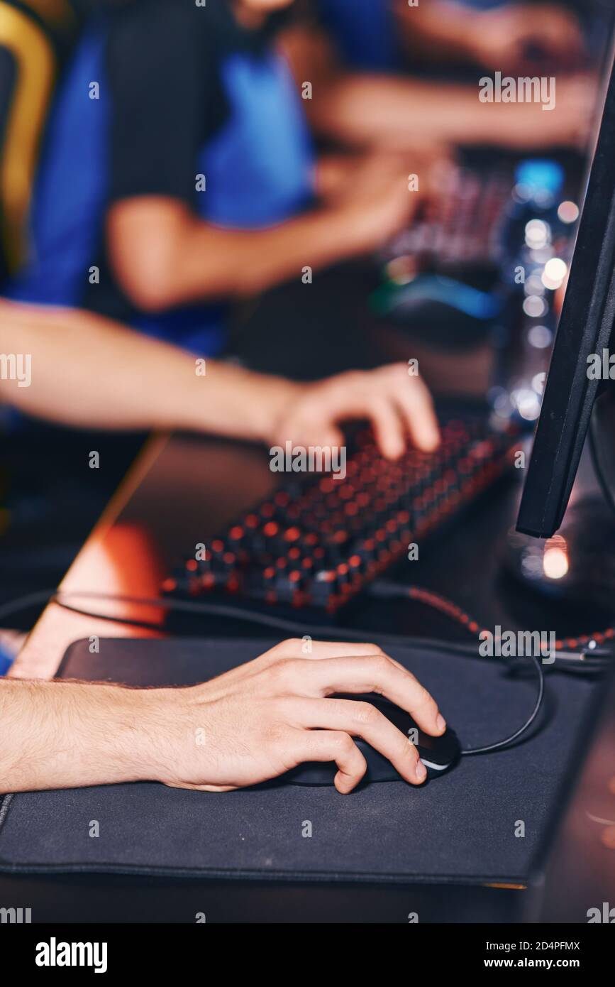 Zugeschnittenes Bild eines Cybersport-Spielers, der Online-Videospiele spielt, an einem eSport-Turnier teilnimmt, konzentriert sich auf männliche Hand Stockfoto