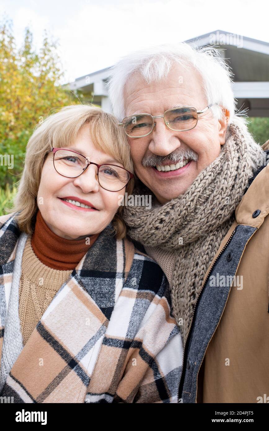 Fröhliche ältere Mann und Frau in stilvollen warmen Casualwear suchen Bei Ihnen Stockfoto