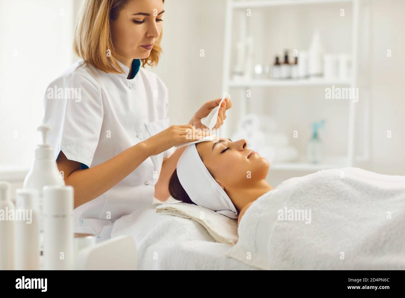 Dermatologe Reinigung entspannt Frau Gesicht mit Baumwollpads in Schönheit Salon Stockfoto