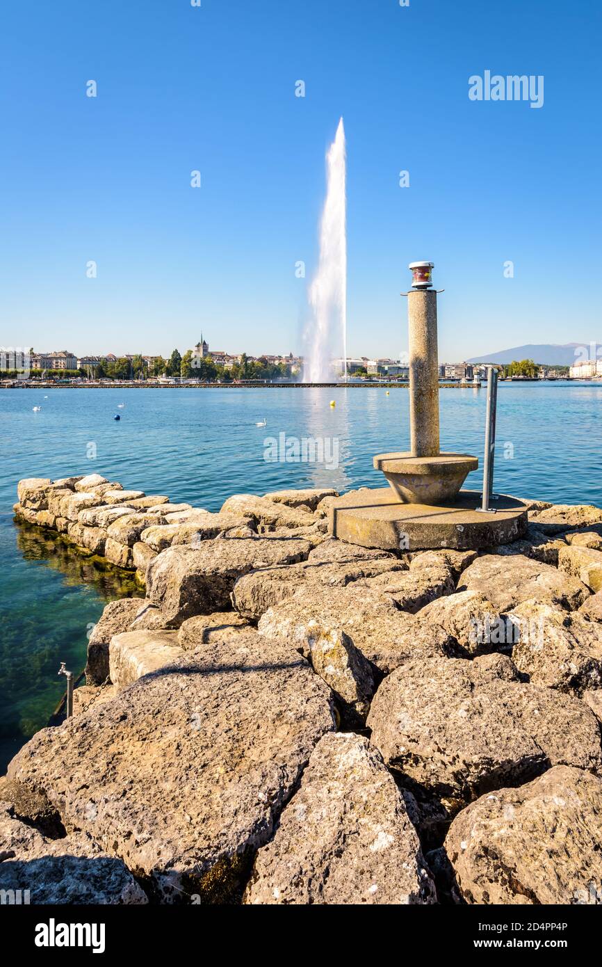 Die Stadt und die Bucht von Genf, Schweiz, mit der Kathedrale und dem symbolträchtigen 140 Meter hohen Wasserstrahlbrunnen auf dem Genfer See, aus einem Stein gesehen Stockfoto