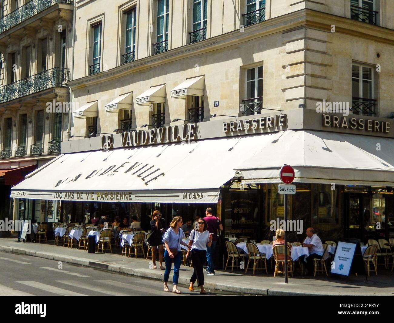 Café in paris mit zwei Pariser Frauen, die vor dem Hotel spazieren Davon Stockfoto