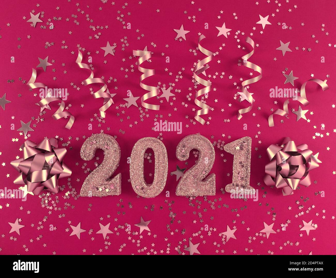 Grußkarte des neuen Jahres 2021. Glitzernde Figuren, Sterne, Schleifen und Bänder auf rosa Hintergrund. Stockfoto