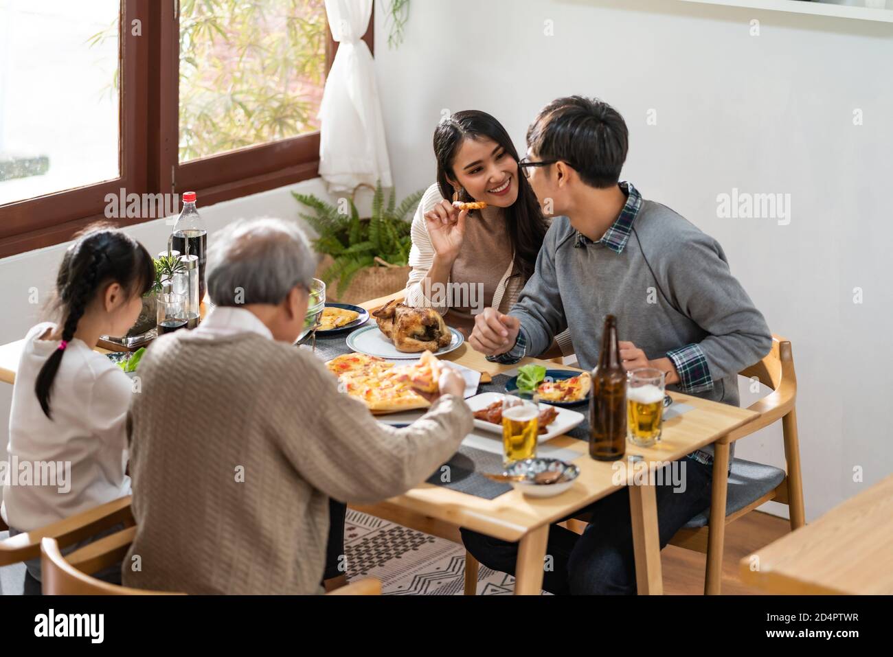 Glücklich asiatische multigenerational Familie von Papa Mama Tochter Mädchen und Großvater essen gemeinsam zu Hause. Glückliche Familie Engagement Zweisamkeit con Stockfoto