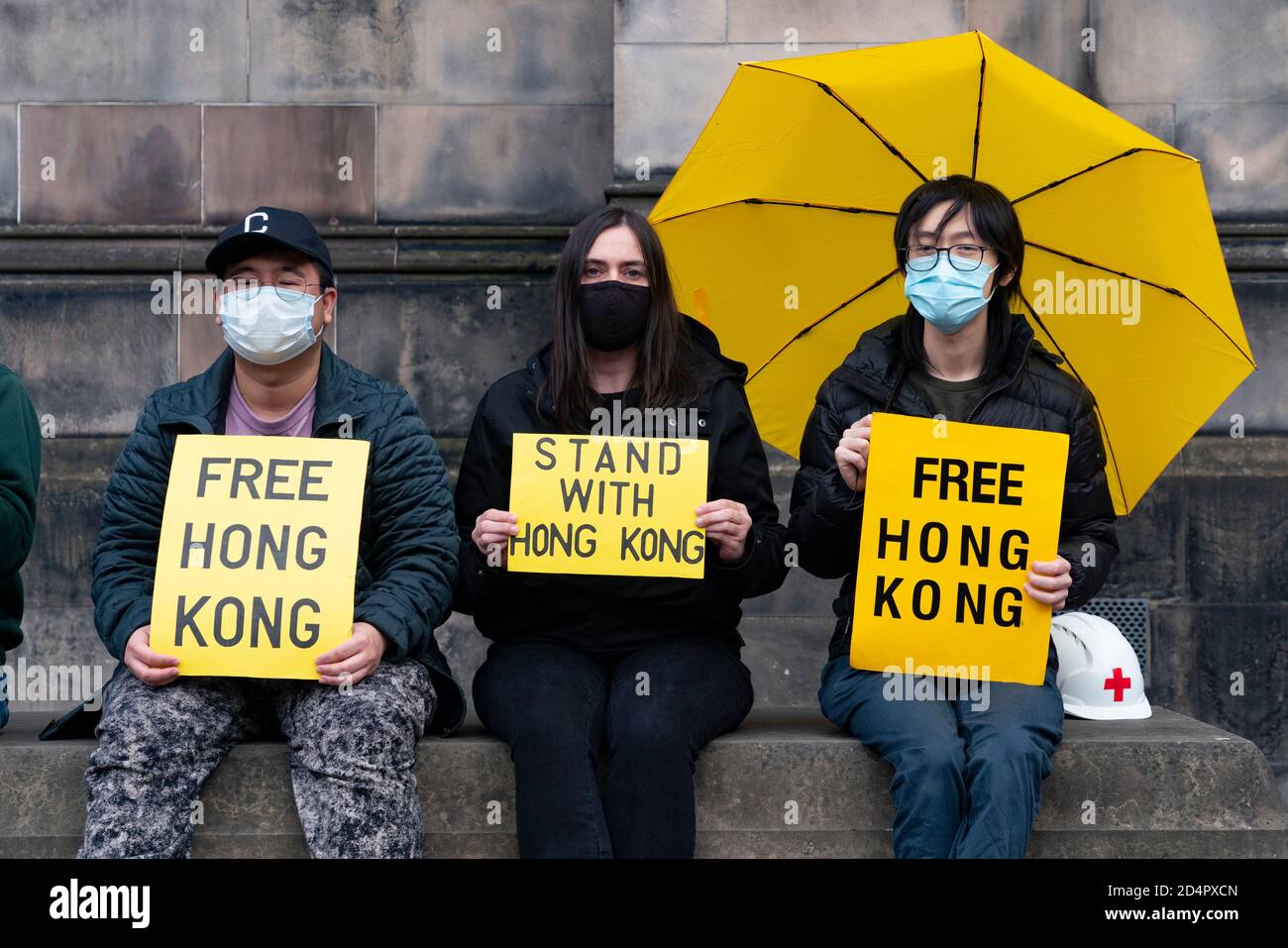 Edinburgh, Schottland, Großbritannien. 10. Oktober 2020. Demonstranten der Pro-Demokratie-Bewegung Hongkongs veranstalteten heute eine Demonstration in der St. Giles Kathedrale. Die Demonstranten protestierten gegen Chinas Verfolgung der ethnischen Minderheit der Uiguren und die neuen nationalen Sicherheitsgesetze, die Hongkong von China auferlegt wurden. Die Demonstranten trugen Gesichtszüge nicht nur als Gesundheitsvorsorge, sondern auch zur Wahrung der Anonymität.das nationale Sicherheitsgesetz bedeutet, dass Hongkonger Staatsangehörige wegen Protestes überall auf der Welt verfolgt werden können. Ein chinesisches Ehepaar aus dem Festland in einer Wohnung gegenüber zerrte die Demonstranten und filmte sie. Stockfoto