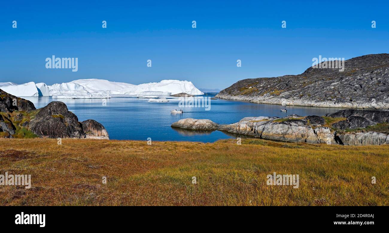 Fischer mit Boot vor gigantischen Eisbergen, UNESCO Weltnaturerbe, Ilulissat, Disko Bay, Westgrönland, Grönland, Nordamerika Stockfoto