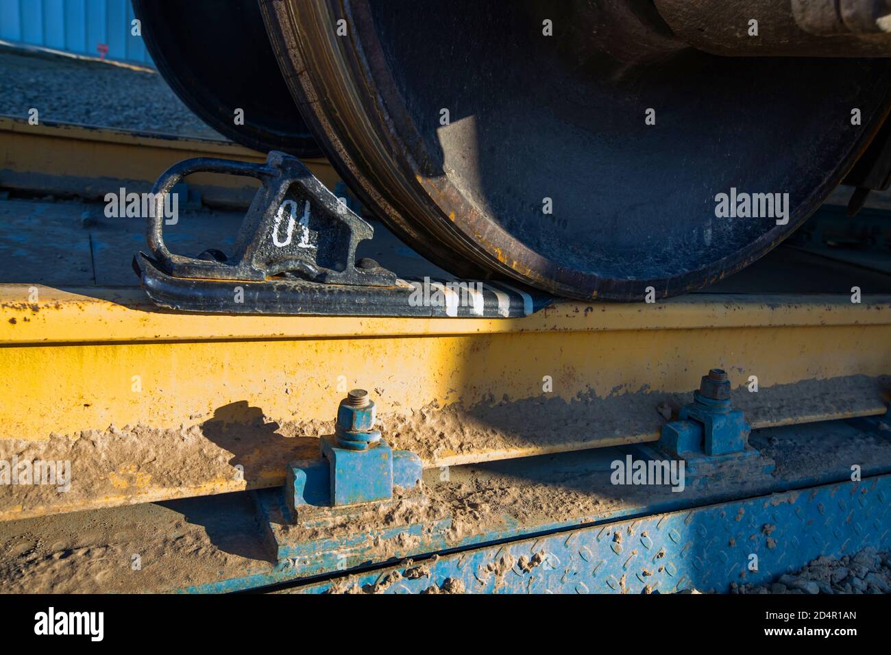 Hopper Auto Eisenbahn Terminal. Phosphat Düngemittel Pflanze. Wagenrad mit Bremsbacke. Gelber Lehmboden auf der Schiene. Nahaufnahme. Stockfoto