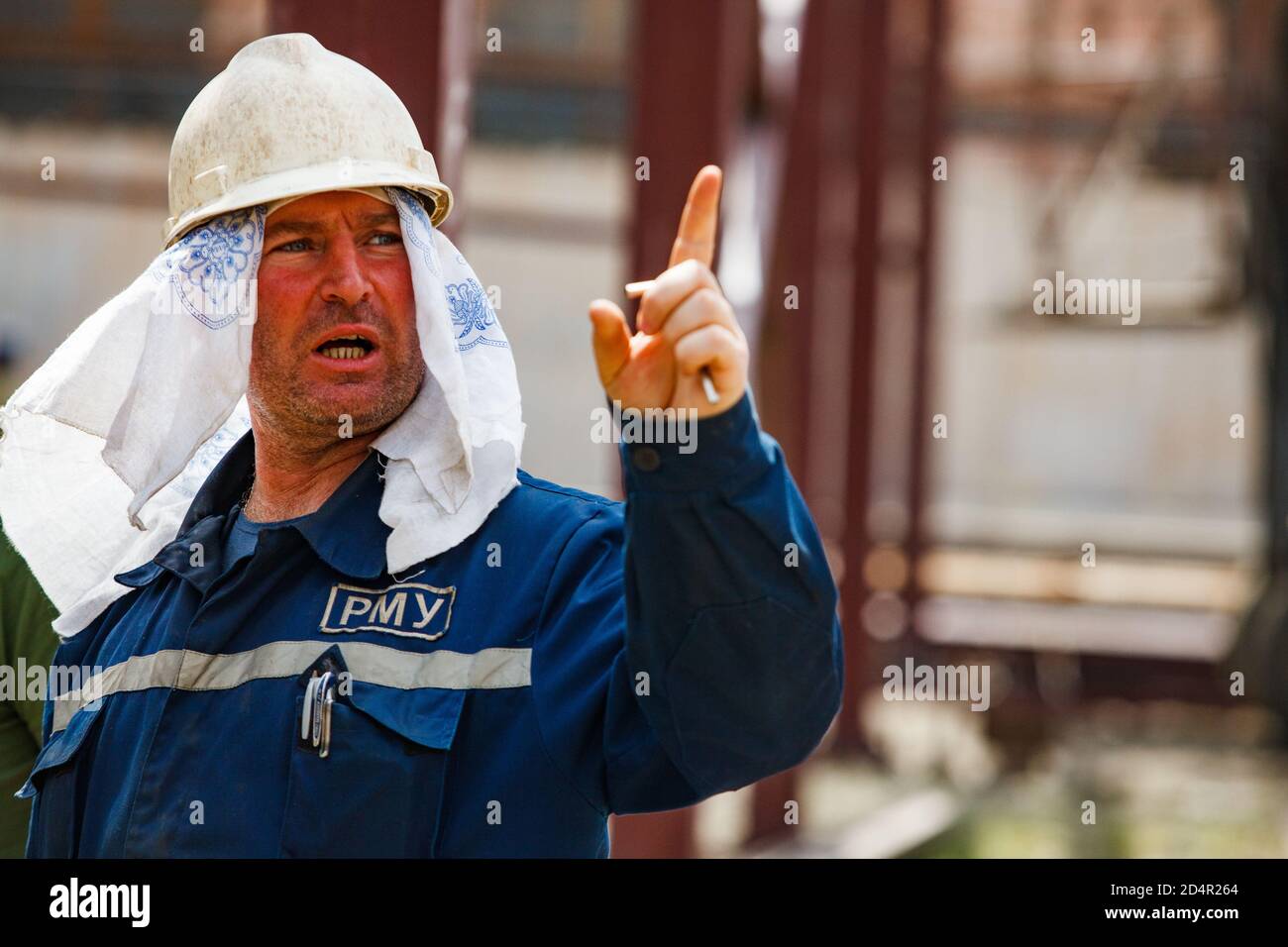 Shymkent, Kasachstan - April 27 2012: Porträt eines usbekischen Arbeiters in weißem Hardhut und Stoffkopfdeckel. Stockfoto