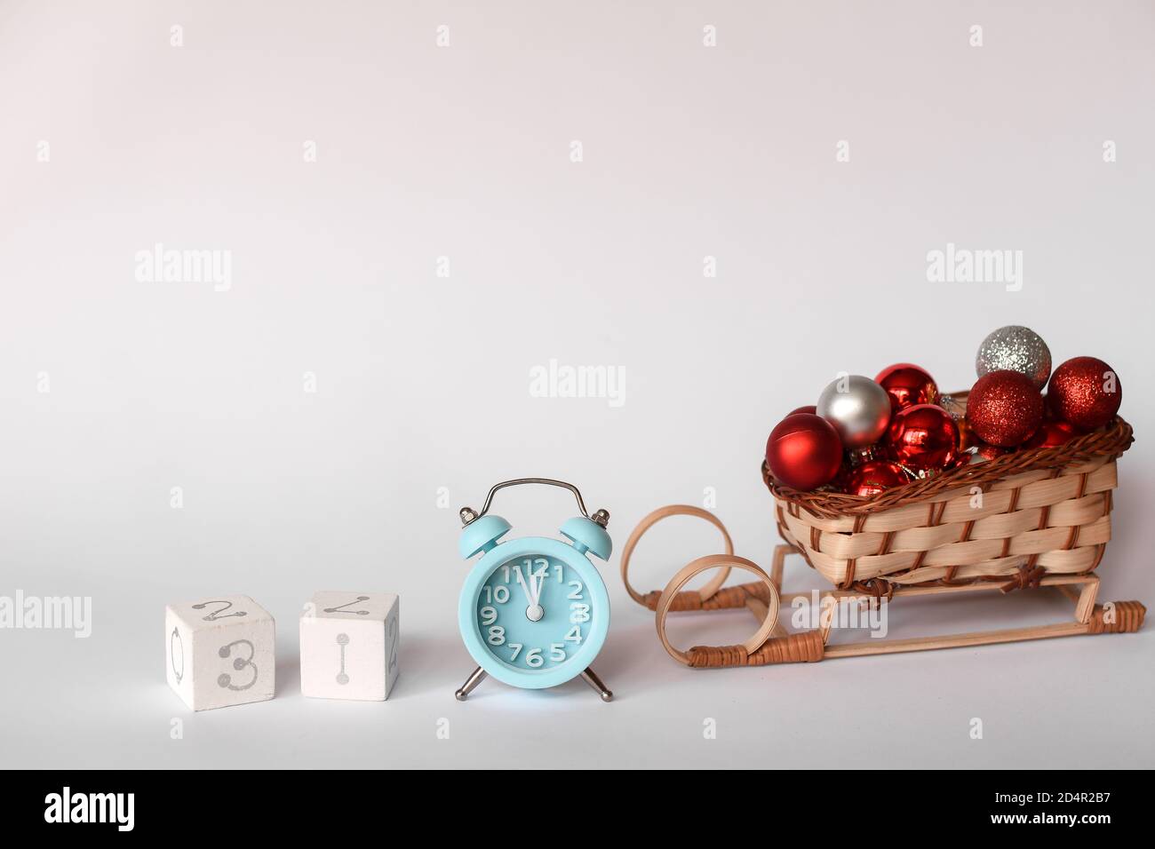 Weihnachtskomposition. Blauer Wecker, Goldene Schneeflocken, Würfel mit der Zahl 31, weihnachtsspielzeug Stockfoto