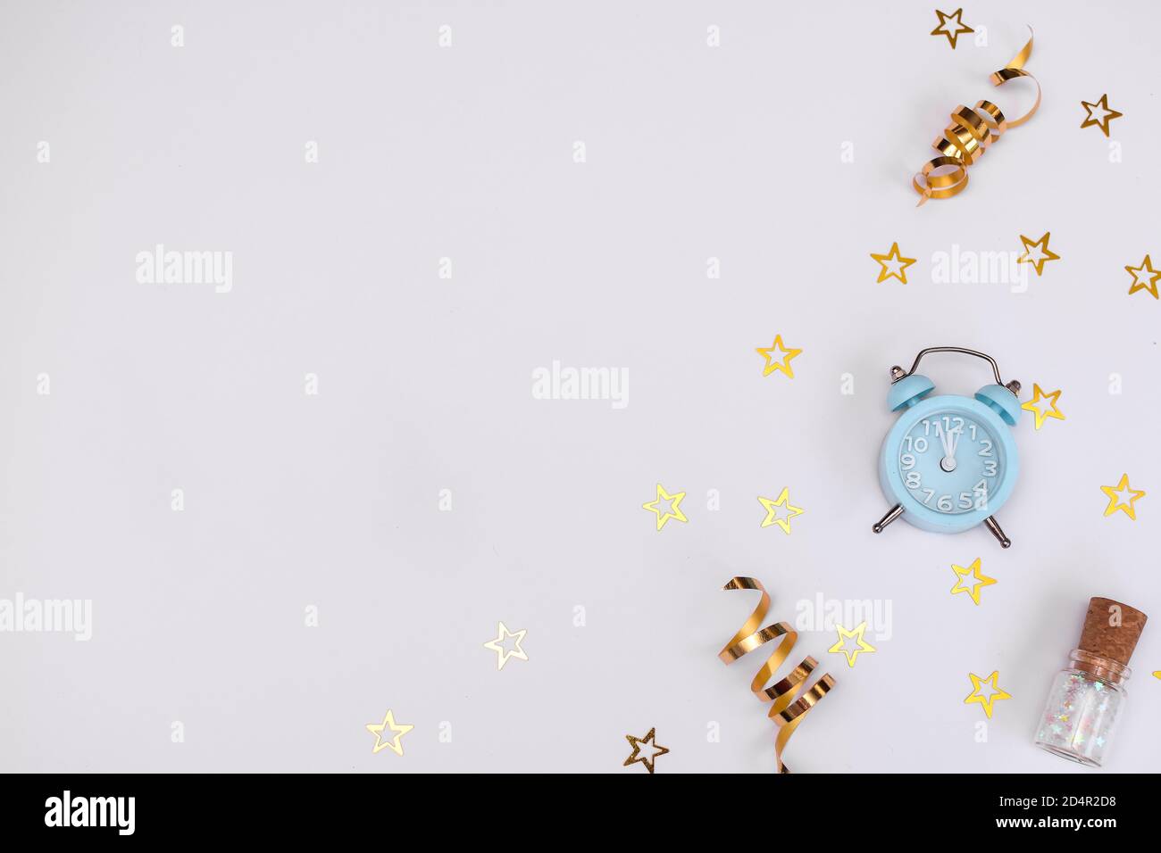 Weihnachtskomposition. Blauer Wecker, Goldene Schneeflocken, Layout auf weißem Hintergrund. Stockfoto