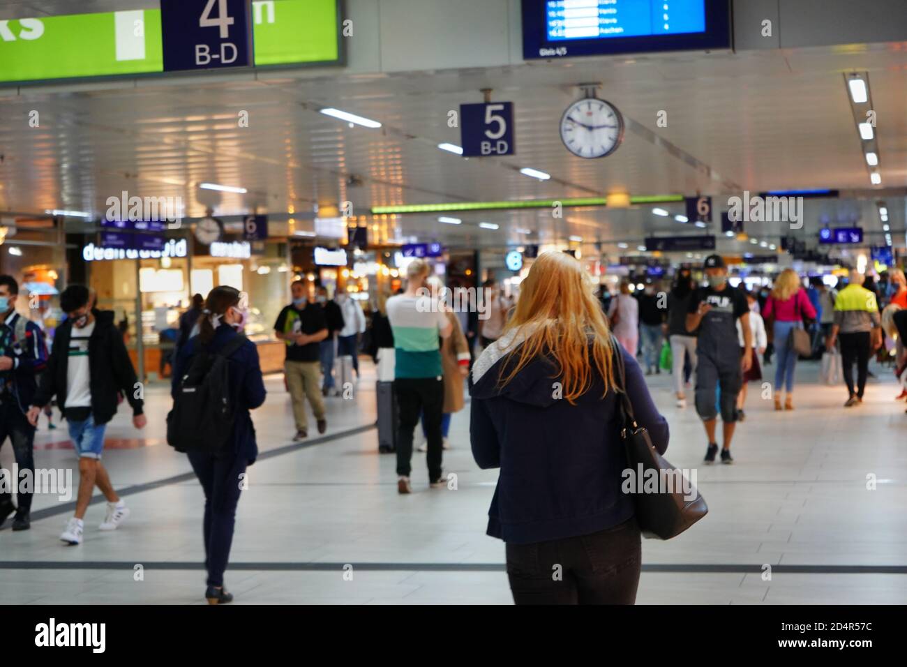 Der stark frequentierten Düsseldorfer Hauptbahnhof. Symbolisches Bild mit selektivem Fokus und unscharfem Hintergrund. Menschen in Masken während der Corona-Krise. Stockfoto