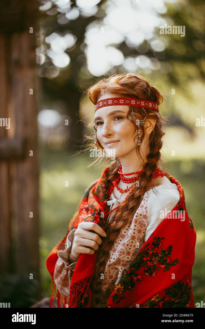 Schöne slawische Mädchen mit langen blonden Haaren und braunen Augen In einem weiß-roten bestickten Anzug und rotem Kleid Auf den Schultern.traditionelle Kleidung von Stockfoto