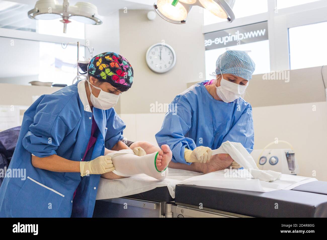 Krankenschwester, die nach der Operation ein System zur Prävention von tiefen Venenthrombosen (DVT) an die Unterschenkel eines Patienten anpasst, ästhetisches Privatkrankenhaus von Aquitaine, Bo Stockfoto