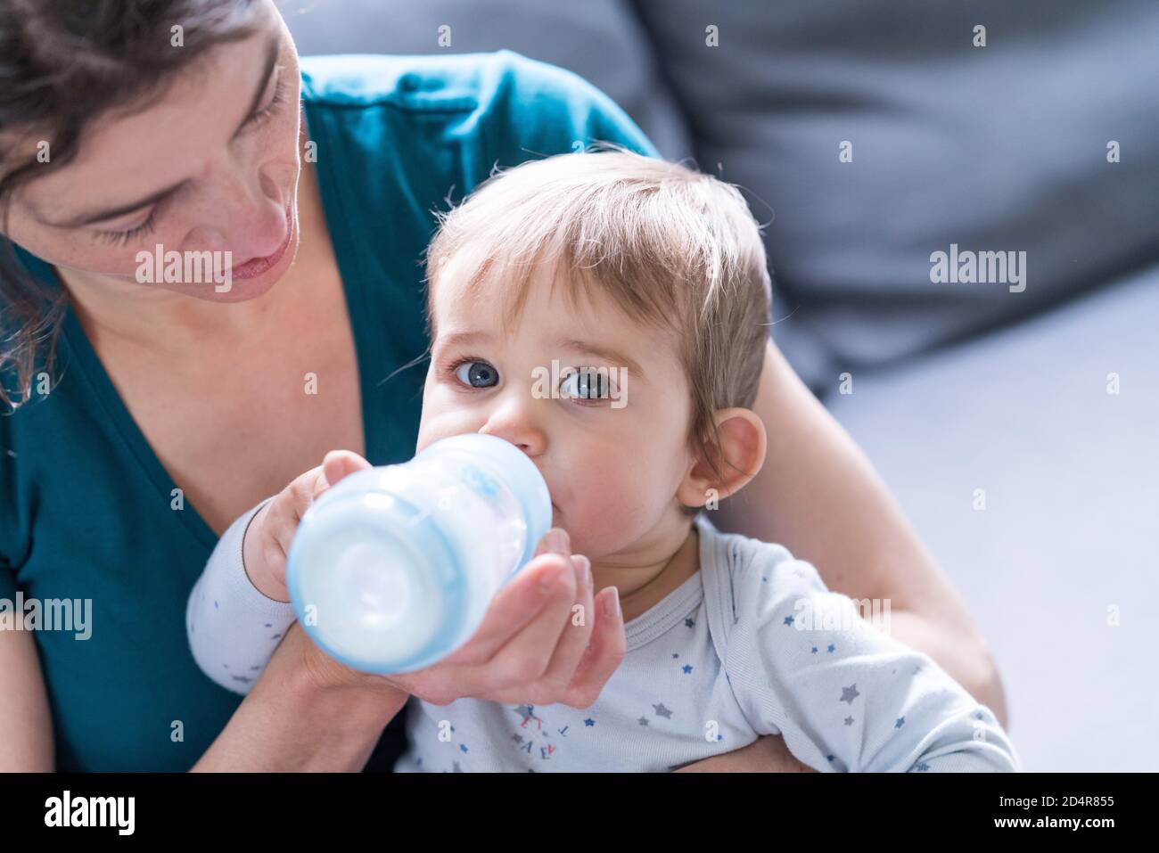 9 Monate Baby Mädchen trinken Milch aus einer Flasche. Stockfoto