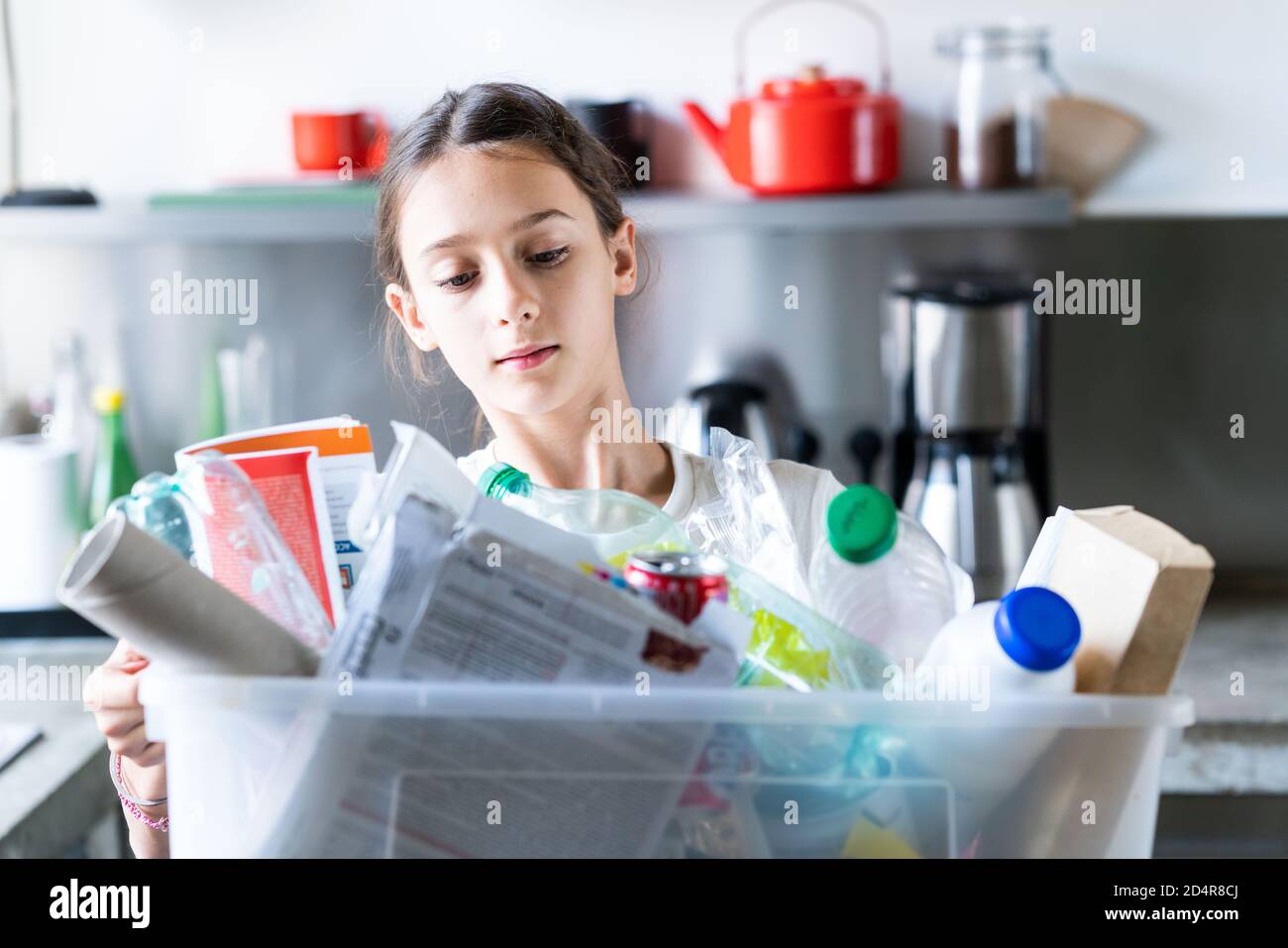 12-jähriges Mädchen, das recycelte Abfälle sortiert. Stockfoto