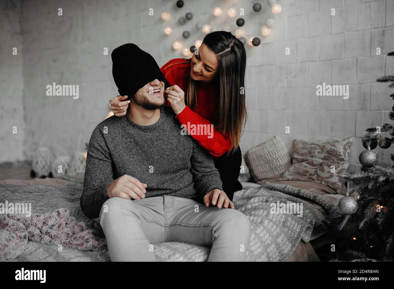 Glücklich liebende Paar genießen Weihnachten Spaß zusammen auf einem bequemen Bett. Schöne kaukasische Paar lachen Zweisamkeit in gemütlichen Raum zu Hause Stockfoto