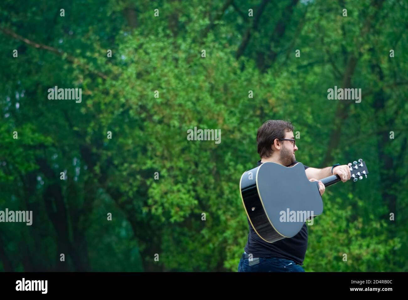 Verärgert Mann brechen akustische Gitarre in der Natur Stockfoto