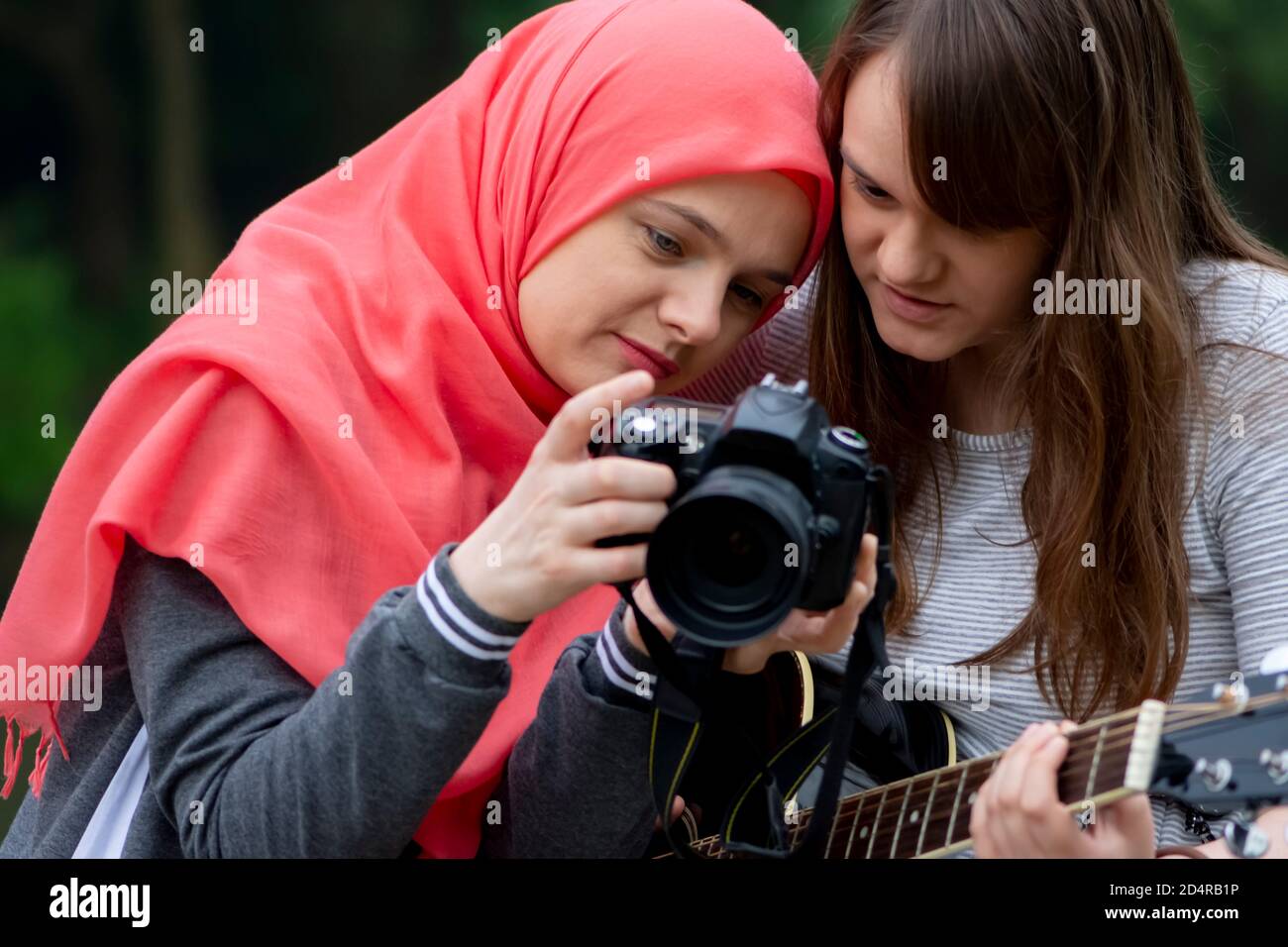 Junge muslimische Mädchen beobachten Fotos auf der professionellen Kamera Stockfoto