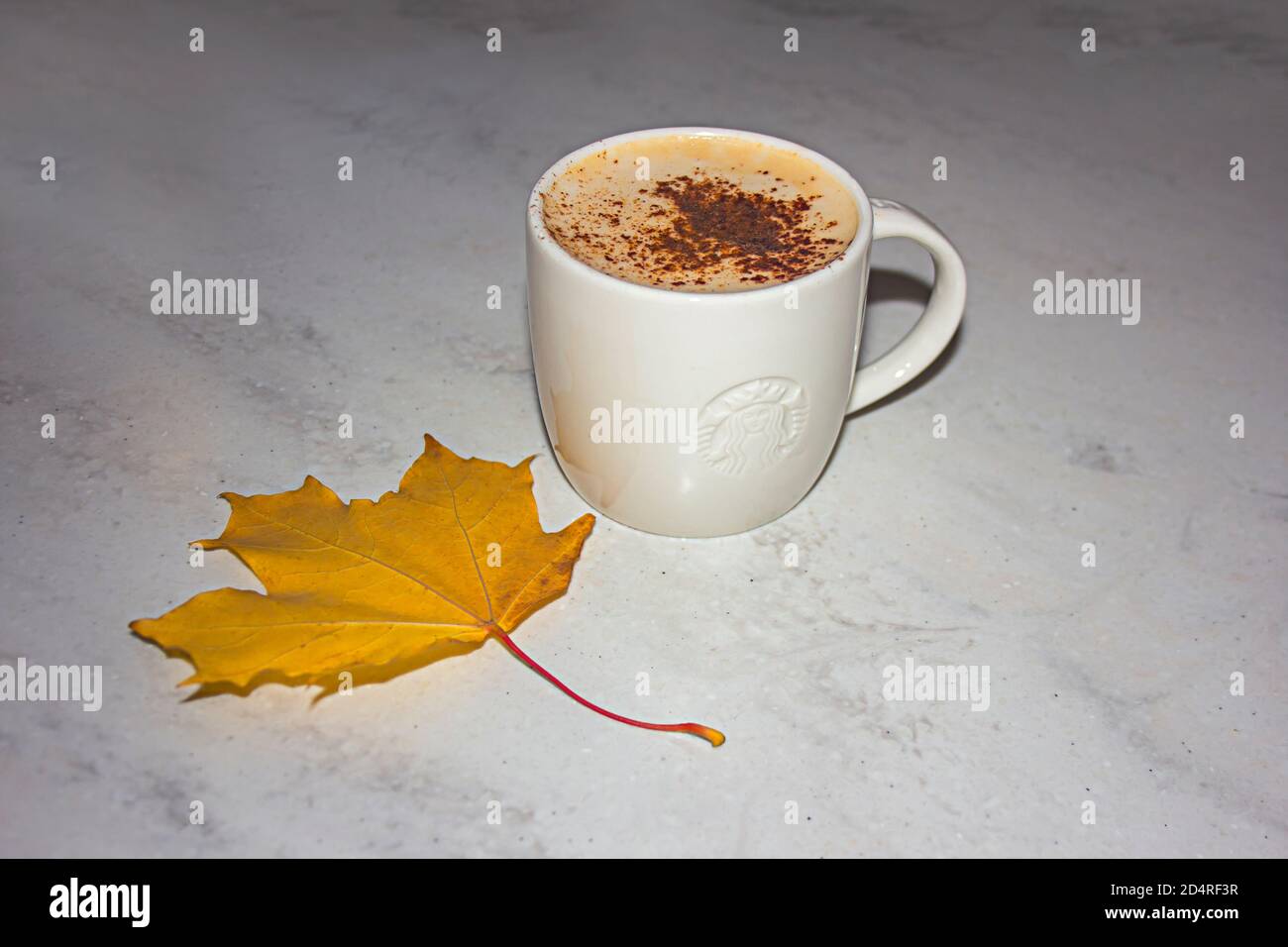 Saint-Petersburg, Russland - 03. OKTOBER 2020: Starbucks Kaffeetasse auf einem Kaffeetisch und ein gelbes Herbstahornblatt Stockfoto