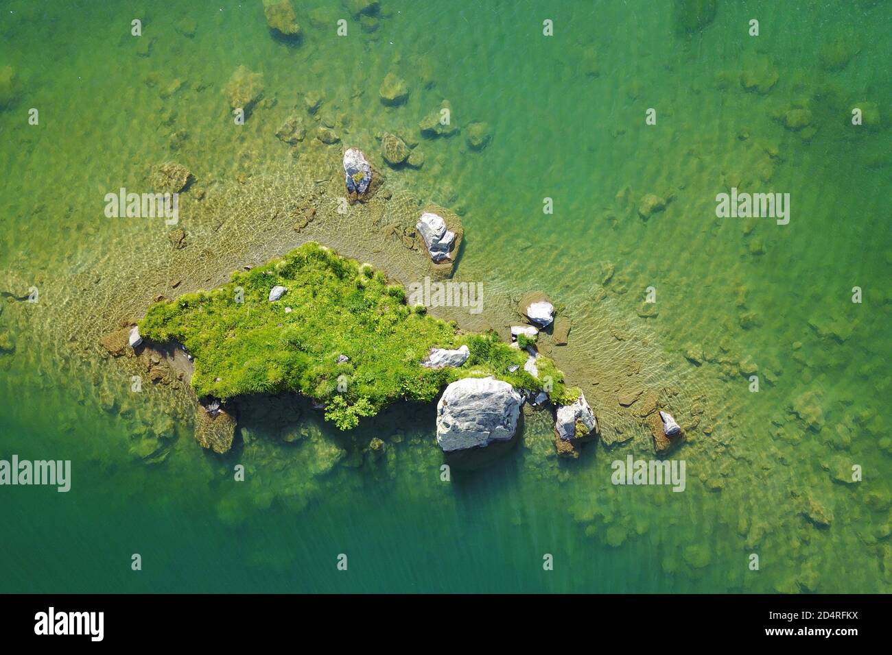 Luftaufnahmen einer kleinen Insel auf einem alpinen See - Lake Louvie, Schweiz Stockfoto