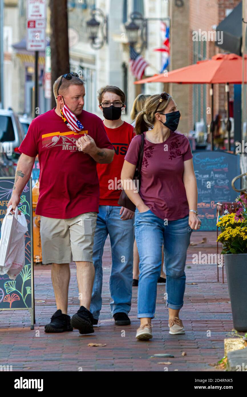 Ellicott City, MD, USA 10/07/2020: Ein kaukasisches Paar und ihr Teenager-Sohn gehen. Mutter und Sohn tragen wegen COVID eine schwarze Gesichtsmaske. Das f Stockfoto