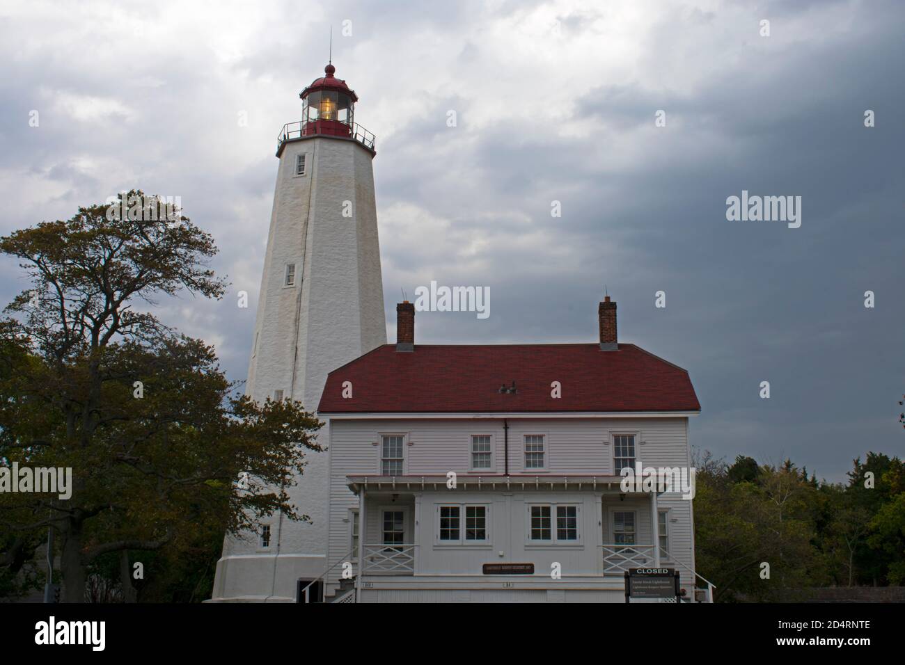 Leuchtturm in Sandy Hook, New Jersey, in der Dämmerung an einem bewölkten Tag mit seinem Licht schwach -30 scheint Stockfoto