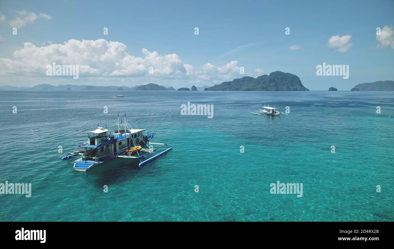Aerial Philippines Ocean Bay: Boot, Schiff an Turquiose Wasseroberfläche. Lokale Kreuzfahrt-Tour für Touristen auf dem Schiff in der Meeresbucht von El Nido Island, Visayas Archipel, Asien. Tropische Meereslandschaft in Drohnenaufnahme Stockfoto