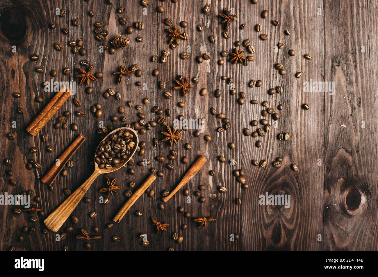 Draufsicht auf hölzernen Vintage Löffel, Kaffeebohnen, Zimt und Sternanis auf Holzhintergrund. Stockfoto