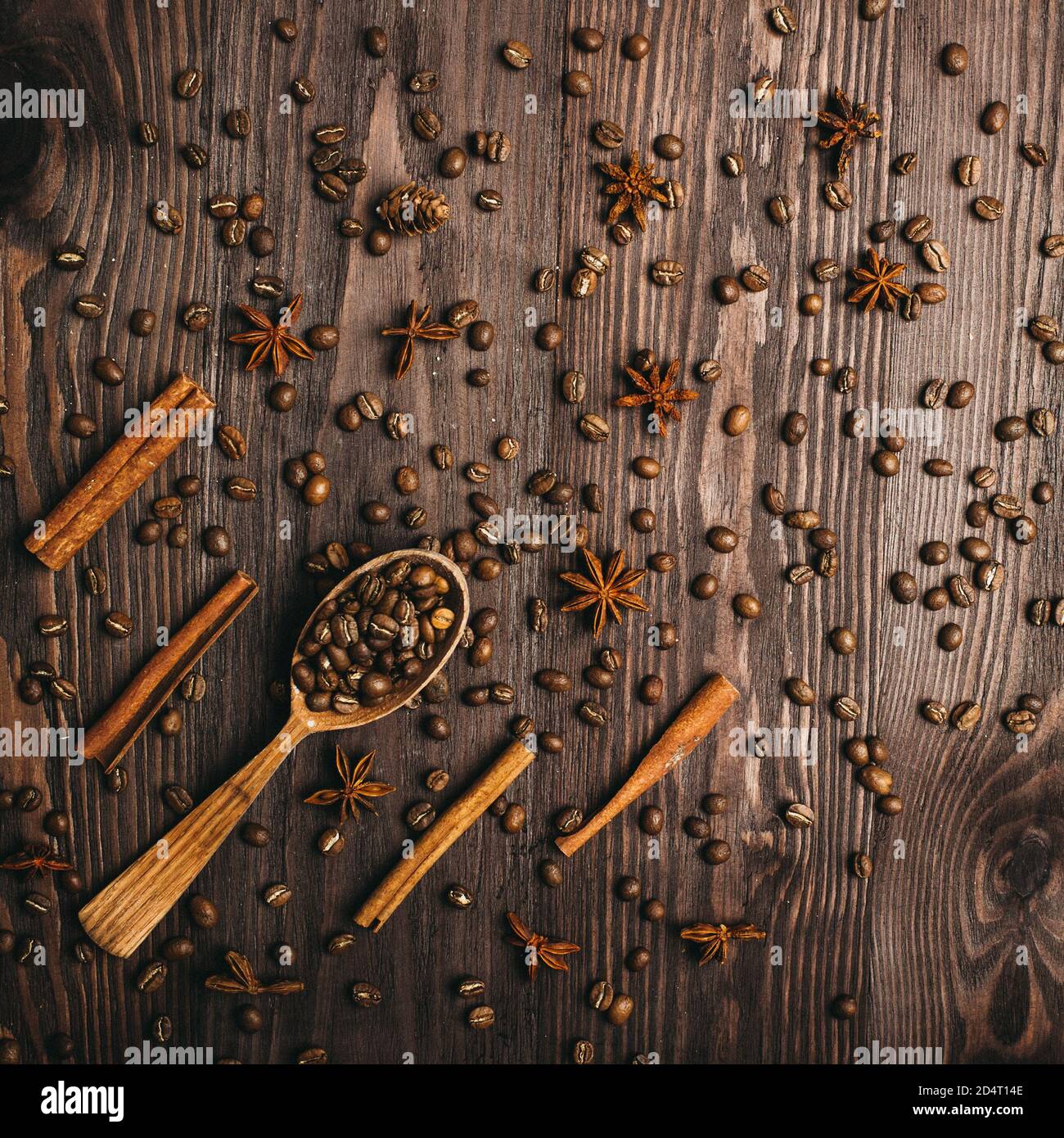 Draufsicht auf hölzernen Vintage Löffel, Kaffeebohnen, Zimt und Sternanis auf Holzhintergrund. Stockfoto