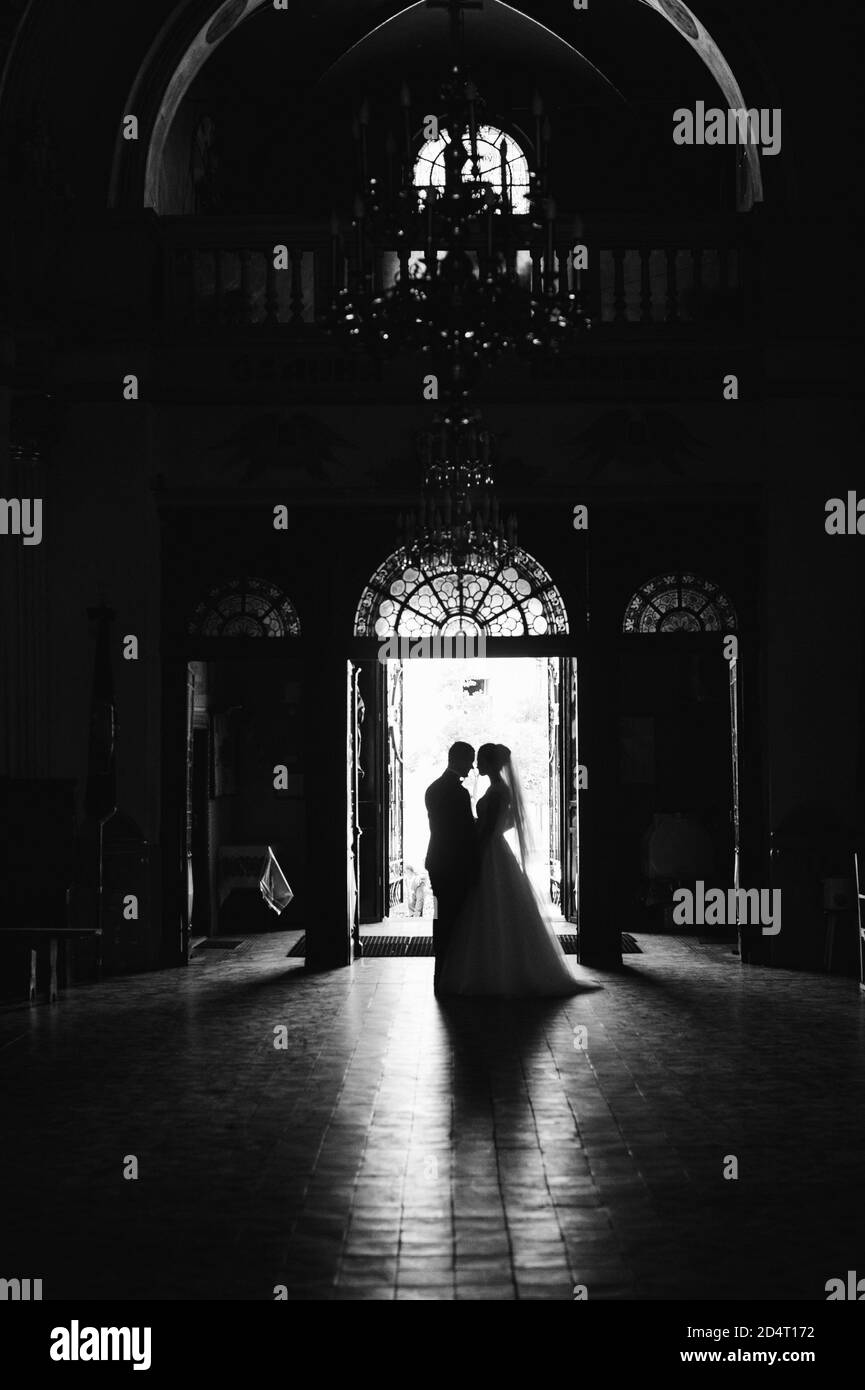 Silhouetten der Braut und des Bräutigams an der Eingangstür im Innenbereich. Stockfoto