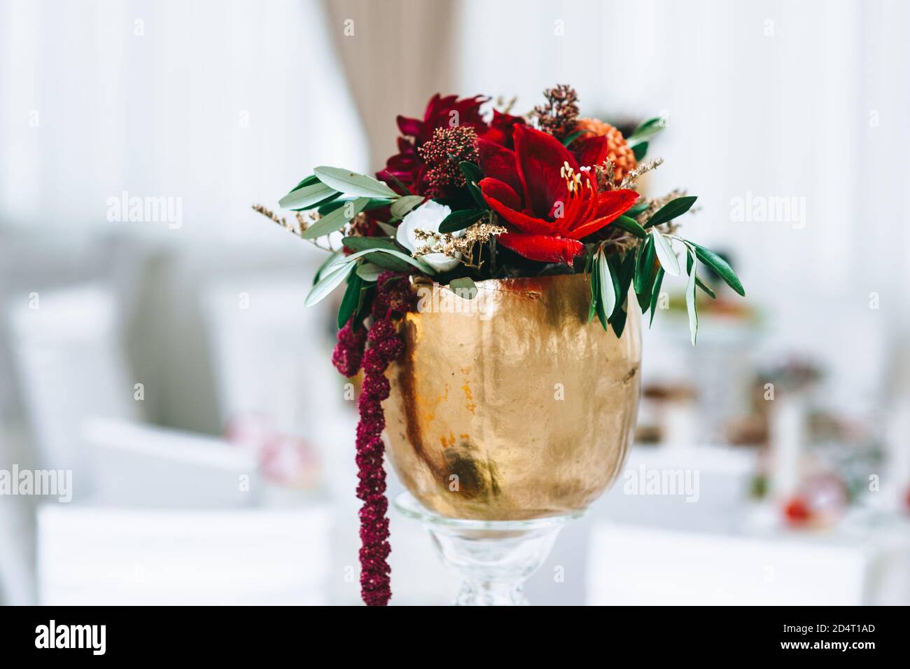 Blumen in kleinen Vintage-Vasen in goldener Farbe auf einem Hochzeitstisch. Stockfoto