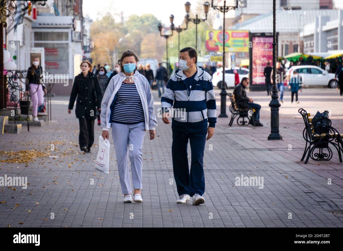 Menschen, die Gesichtsmasken als vorbeugende Maßnahme tragen, gehen auf der Kommunalnaya Straße. Aufgrund der wachsenden Zahl der Infizierten in Russland werden Rentner und Menschen mit chronischen Krankheiten gebeten, die empfohlene Selbstisolation zu beobachten. Stockfoto