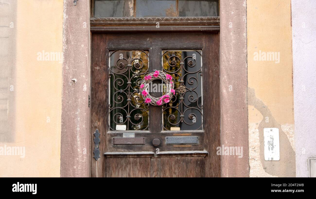 Alte Tür mit einem Kranz aus Blumen Stockfoto