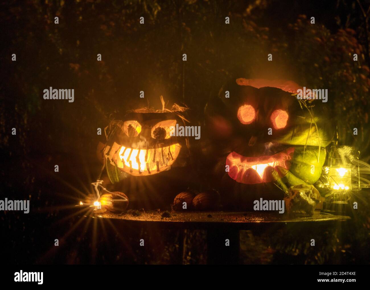Halloween, ein brennender Kürbis mit einem gruseligen Gesicht auf einem dunklen Hintergrund. Grauer Rauch kommt heraus, Halloween Zeit. Der Fall Stockfoto