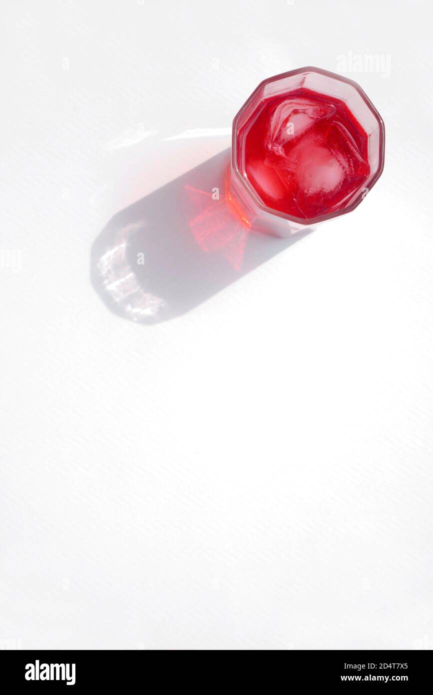 ROTER SHERBET MIT EIS IN EINEM GLAS MIT EINEM STARKEN SCHATTEN Stockfoto