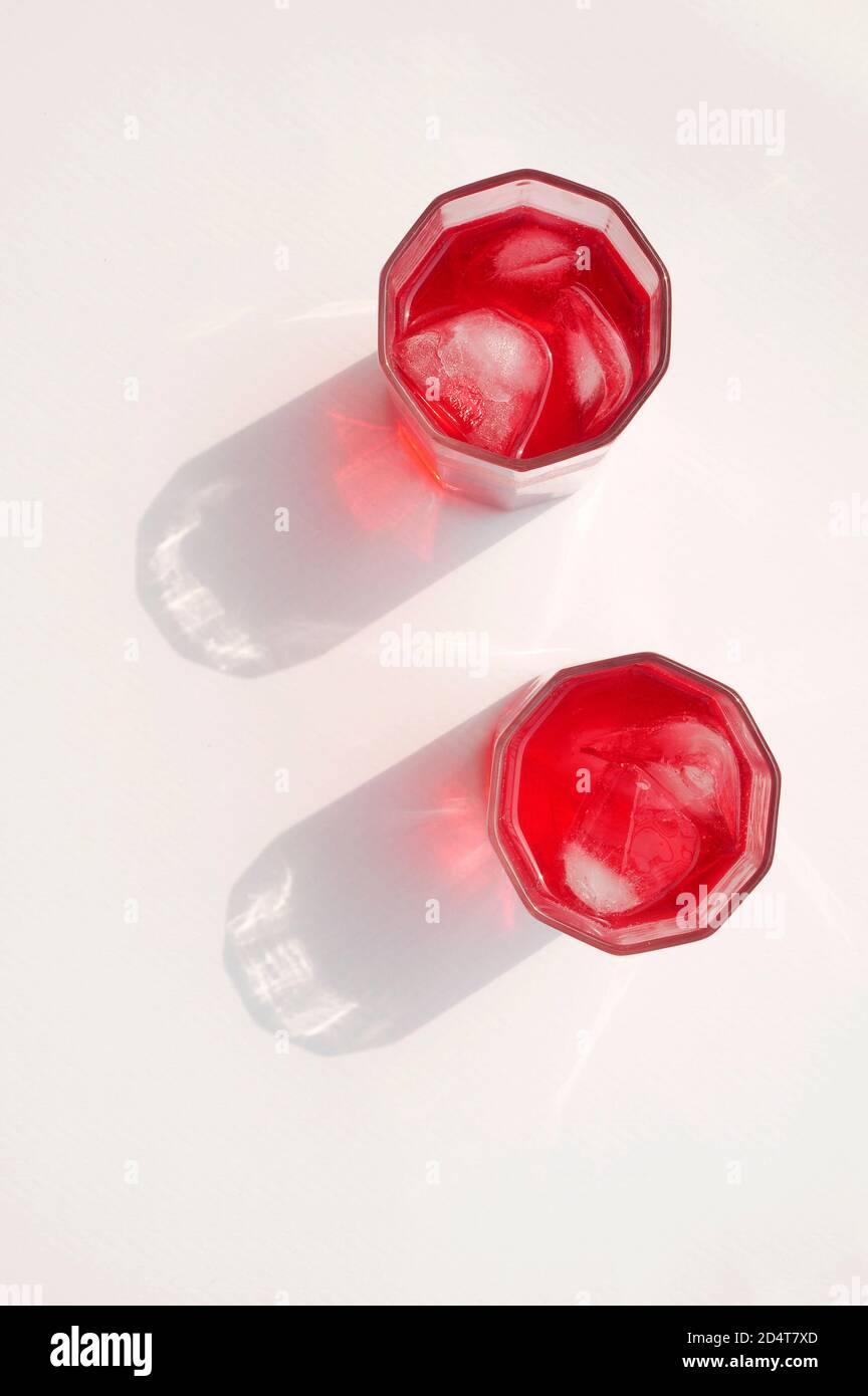 ROTER SHERBET MIT EIS IN EINEM GLAS MIT EINEM STARKEN SCHATTEN Stockfoto
