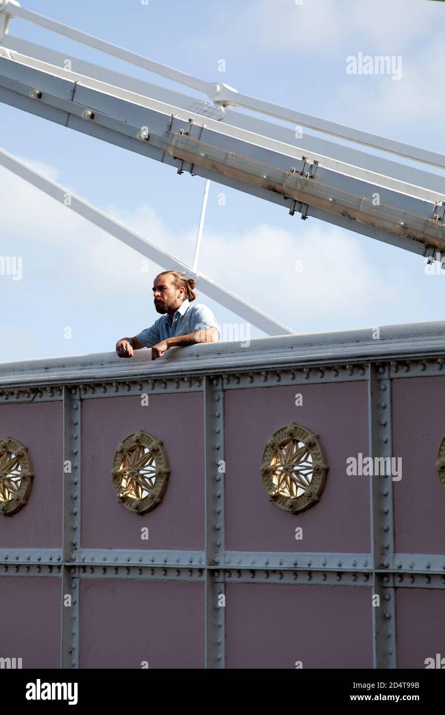Bärtiger Mann in kurzen Ärmeln stehend auf Brücke Stockfoto