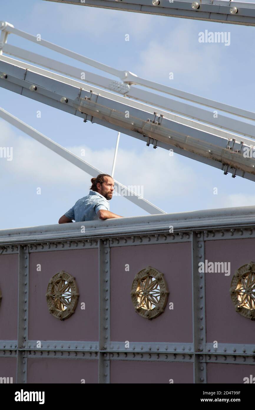 Bärtiger Mann in kurzen Ärmeln stehend auf Brücke Stockfoto