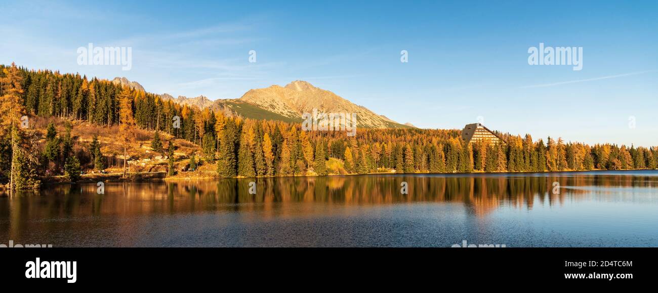 Strbske pleso See mit Gipfeln auf dem Hintergrund und bunt Bäume im Herbst Vysoke Tatry Berge in der Slowakei Stockfoto