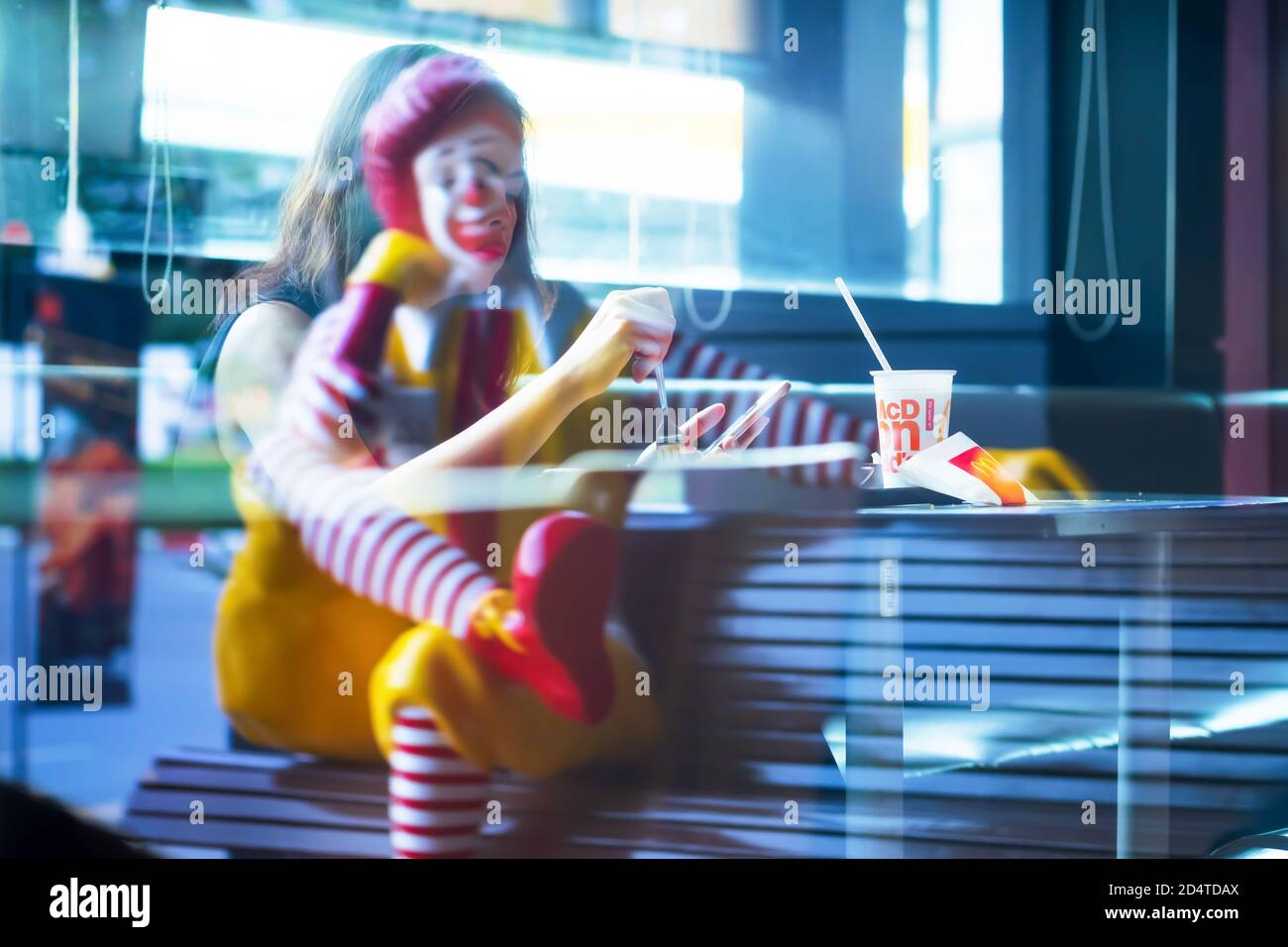 Bangkok, Thailand - 9. JULI 2019: Eine Ronald McDonald Statue und asiatische Frau Reflexion auf dem Spiegel des McDonald's Fast-Food-Restaurant. Bangkok. Stockfoto
